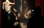 Une personne regarde un tableau du Caravage au Palazzo Reale à Milan, le 28 septembre 2018