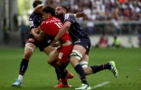 Le demi d'ouverture de Toulouse Romain Ntamack (centre) plaqué par les Bordelais Bastien Vergnes Taillefer (gauche) et Pierre Bochaton (droite) lors de la demi-finale de Champions Cup, le 4 mai 2025 à Bordeaux 