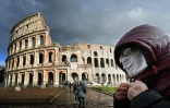 Un homme portant un masque de protection passe devant le Colisée à Rome le 7 mars 2020
