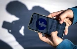 Un adolescent consulte Facebook sur son téléphone portable, le 24 octobre 2025 à Gosford, en Australie