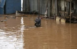 Les habitants du bidonville de Mathare traversent le quartier inondé à la suite de fortes pluies sur Nairobi, le 24 avril 2024 au Kenya