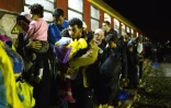 Des migrants s'apprêtent à monter dans un train près de Gevgelija le 16 octobre 2015 à la frontière entre la Grèce et la Macédoine