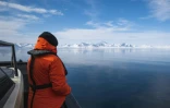 Un passager du bateau hybride diesel-électrique Kvitbjorn lors d'une excursion dans la baie de Borebukta, le 3 mai 2022 dans l'archipel du Svalbard, en Arctique