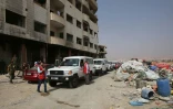 Des ambulances du Croissant rouge escortés par des soldats de l'armée syrienne dans la ville rebelle de Daraya, le 26 août 2016