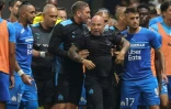 Le milieu de terrain de Marseille, Dimitri Payet (g) et l'attaquant turc Cengiz Under (d) tentent de calmer leur entraîneur, l'Argentin Jorge Sampaoli, après l'envahissement de supporters niçois lors du match de Ligue 1, le 22 août 2021 à l'Allianz Riviera