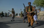 Des forces de sécurité afghanes et des miliciens anti-taliban montent la garde dans une rue d'Enjil, dans la province d'Herat, le 30 juillet 2021. 