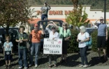 Des habitants le long de la route regardent passer la voiture du président Barack Obama, le 9 octobre 2015 à Roseburg