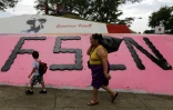Une femme et un enfant marche devant un monument à la mémoire du révolutionnaire Augusto C. Sandino, à Managua, le 17 juillet 2018