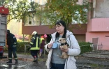 Une femme avec son chien devant un bâtiment touché par une attaque russe à Kharkiv, Ukraine, le 12 octobre 2026