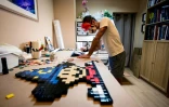 Le street-artiste In The Woup travaille sur une mosaïque inspirée de l'univers "Super Mario", dans son studio à Lyon, le 28 août 2025