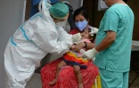 Un personnel de santé effectue un prélèvement sur une enfant dans un centre de test, le 19 août 2020 à Hyderabad, en Inde