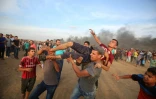 Des secouristes palestiniens portent un manifestant blessé près de la frontière entre la bande de Gaza et Israël, le 5 octobre 2018