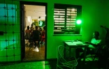 Un jeune homme regarde son téléphone au bar La Bombilla verde, à La Havane, le 27 septembre 2026