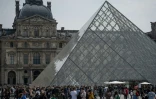 Des touristes font la queue devant la pyramide du Louvre le 29 avril 2022