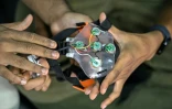 Akash Kulgod (d), cofondateur de Dognosis, tient un dispositif d'interface cerveau-machine (ICM), le 28 juillet 2026 à Kempohalli, en périphérie de Bangalore, en Inde