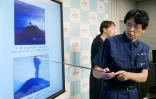 Un scientifique de l'agence météorologique japonaise montre le mont Asama en éruption lors d'une conférence de presse, le 8 août 2019 à Tokyo