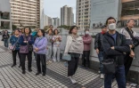 Des habitants observent des appartements encore en flammes après un violent incendie qui a ravagé plusieurs immeubles du complexe résidentiel Wang Fuk Court à Hong Kong, le 27 novembre 2025 