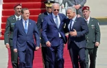 Le président américain Joe Biden (C) accueilli à l'aéroport Ben Gourion de Tel-Aviv par le président israélien Isaac Herzog (G) et le Premier ministre Yaïr Lapid, le 13 juillet 2022 