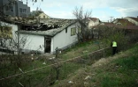 Un policier établit un périmètre de sécurité autour d'une discothèque ravagée la veille par un incendie, le 17 mars 2025 à Kocani, en Macédoine du Nord
