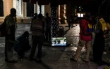 Des passants regardent la télévision dans la rue, place Bolivar, le 13 décembre 2019 à Caracas, au Venezuela