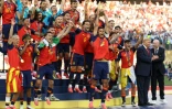 Le milieu de terrain espagnol, Rodri, brandit le trophée de la Coupe du monde aux côtés de ses coéquipiers, encadré par le président américain Donald Trump (2e à droite) et le président de la Fifa Gianni Infantino (à droite), après avoir remporté la finale du Mondial-2026 contre l'Argentine, à East Rutherford, le 19 juillet 2026