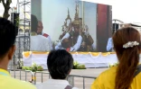 Des Thaïlandais suivent sur un écran géant la cérémonie de couronnement du roi Maja Vajiralongkorn, le 4 mai 2019 à Bangkok