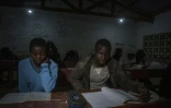 Des écoliers étudient à la lumière des ampoules dans le village de Yobe Nkosi  dans le Nord du Malawi, éclairés grâce à une petite centrale hydro-électrique artisanale