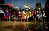 Des gens font la queue à travers les innondations, le 24 décembre 2015 à Calumpit Bulacan, au nord du Manille
