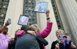 Des proches de victimes, dont Lori Schott (c), sortent du tribunal supérieur de Los Angeles tenant les portraits de leurs êtres chers à Los Angeles, le 25 mars 2026 en Californie