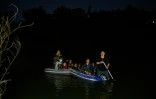 Un passeur rame sur son bateau pour traverser le Rio Grande avec un groupe de migrants originaires du Honduras et du Guatemala entre Miguel Aleman, au Mexique, et Roma, aux États-Unis, le 28 mars 2021