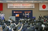 Le président de Hon Hai Precision, connu aussi sous le nom de Foxconn, Terry Guo (C) et le vice-président Tai Jeng-wu (G) posent avec le président de Sharp Kozo Takahashi, lors d'une conférence de presse à Osaka le 2 avril 2016