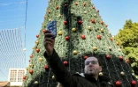 Milad Ayyad, un Palestinien chrétien orthodoxe de la bande de Gaza, devant un sapin de Noël sur le parvis de la basilique de la Nativité à Bethléem, en Cisjordanie occupée, le 26 décembre 2021