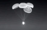 La capsule Dragon de SpaceX transportant le Français Thomas Pesquet et trois autres astronautes, ses quatre parachutes principaux déployés, juste avant son amerrissage de nuit dans le Golfe du Mexique, le 8 novembre 2021