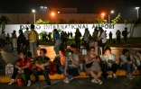 Des voyageurs attendent de recevoir l'autorisation du personnel de l'aéroport pour entrer dans l'aéroport de Davao, le 10 octobre 2025, après une réplique d'un tremblement de terre précédent aux Philippines