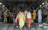 Des Afghans montent à bord d'un avion de l'US Air Force, le 20 août 2021 à l'aéroport de Kaboul