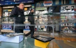 Des hommes passent devant des magasins de téléphones, le 12 janvier 2025 à Damas, en Syrie
