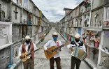 Les chanteurs Roberto Maldonado (g) Humberto Montès (c) et Israel Mundo (d) au cimetière de Ciudad Nezahualcóyotl, attendent, le 3 juin 2020 des familles qui leur demanderaient de chanter lors de l'enterrement de leurs proches