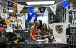 Une employée du magasin "Space Shirts" dédié à l'espace, et Brenda Mulberry sa fondatrice (à droite), près de Cap Canaveral en Floride le 27 août 2022