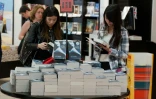 Des jeunes femmes regardent le livre "Cinquante nuances de Grey" le 19 juillet 2012 à Londres