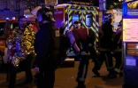 Un pompier transporte une victime des attaques survenues dans le centre de Paris, le 13 novembre 2015