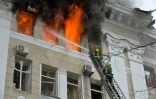 Des pompiers luttent contre un incendie dans le bâtiment du service de sécurité régional SBU, après une frappe russe, le 2 mars 2022 à Kharkiv