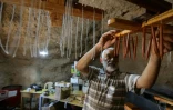 Le père Youssef Al-Halabi fabrique des bougies dans une grotte du monastère de Mar Moussa, le 11 juin 2022 en Syrie