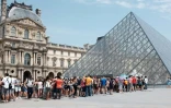 Touristes faisant la queue pour entrer au Louvre, Ă  Paris, le 2 juillet 2015