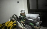 Un jeune garçon syrien blessé est assis sur un lit d'hôpital au poste frontière de Bab al-Hawa entre la Turquie et la Syrie, le 16 décembre 2016