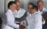 Le président cubain Raul Castro félicite le président colombien Juan Manuel Santos (G) et le leader des FARC Rodrigo Londono alias "Timochenko" (D) qui se serrent la main après la signaturz de l'accord de paix, le 26 septembre 2016