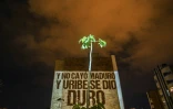 Des membres de "la nouvelle bande de la terrasse" projettent un slogan sur le mur d'un immeuble, le 9 août 2020 à Medellin, en Colombie