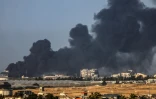 Une photo prise de Rafah montrant un nuage de fumée s'élevant le 22 janvier 2024 au dessus de Khan Younès dans le sud de Gaza après des combats entre l'armée israélienne et le groupe islamiste palestinien du Hamas