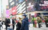 Des personnes portant des masques de protection se promènent à Times Square, le 14 mars 2020 à New York