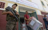 Un membre de l'instance chargée des élections en Tunisie apporte des urnes dans un bureau de vote à la veille du scrutin présidentiel, le 14 septembre 2019 à Tunis