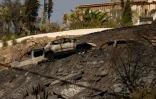 Des voitures calcinées près d'une maison sont visibles après un incendie de forêt ayant fait au moins 12 morts, à Bedar, dans la province d'Almería, le 11 juillet 2026
